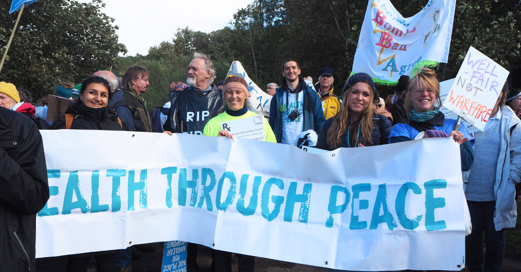 Medact members hold a 'Health Through Peace' banner at a protest