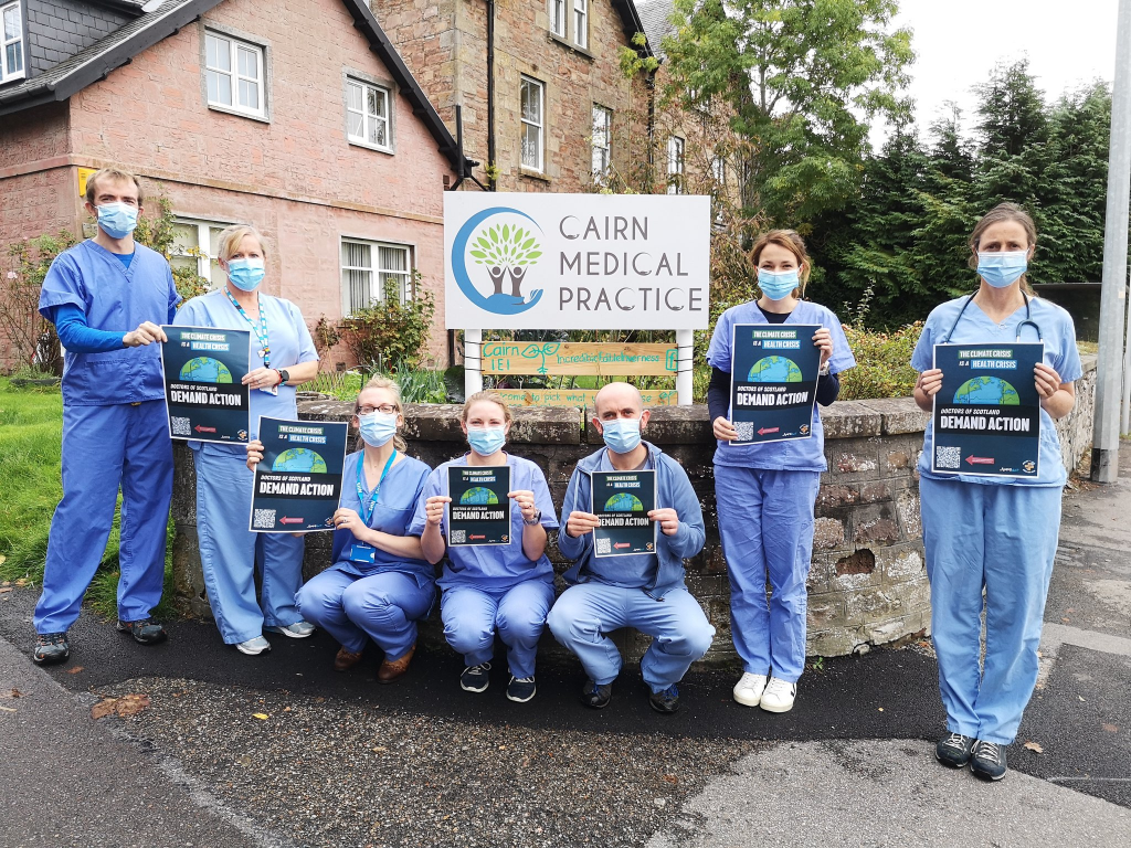 Collection of Scottish Doctors in scrubs holding posters