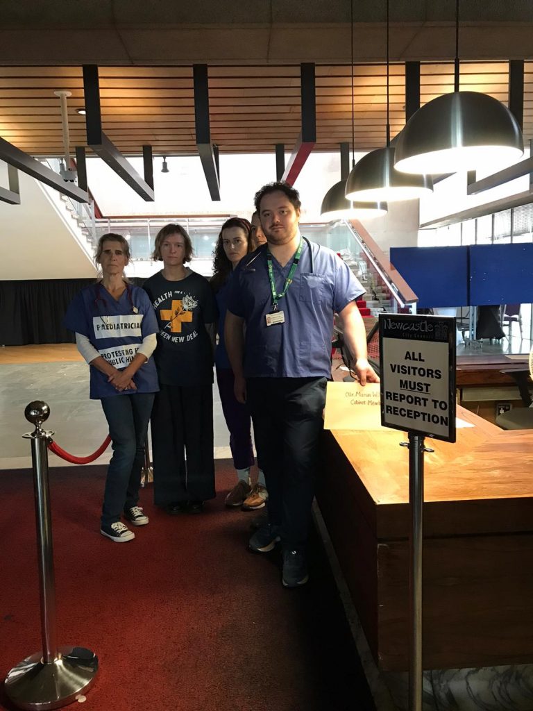 Health-worker Medact North East members handing in an open letter in an envelope at the lobby of the Newcastle Civi Centre