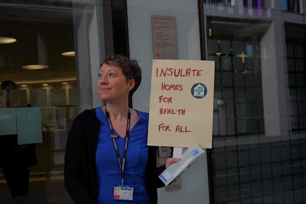 Health worker Dr LJ Smith at Whitehall with a placard that reads 'Insulate homes for health for all'