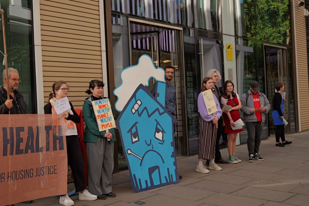 Protesters with a huge blue 'Unhappy Home' model at Whitehall