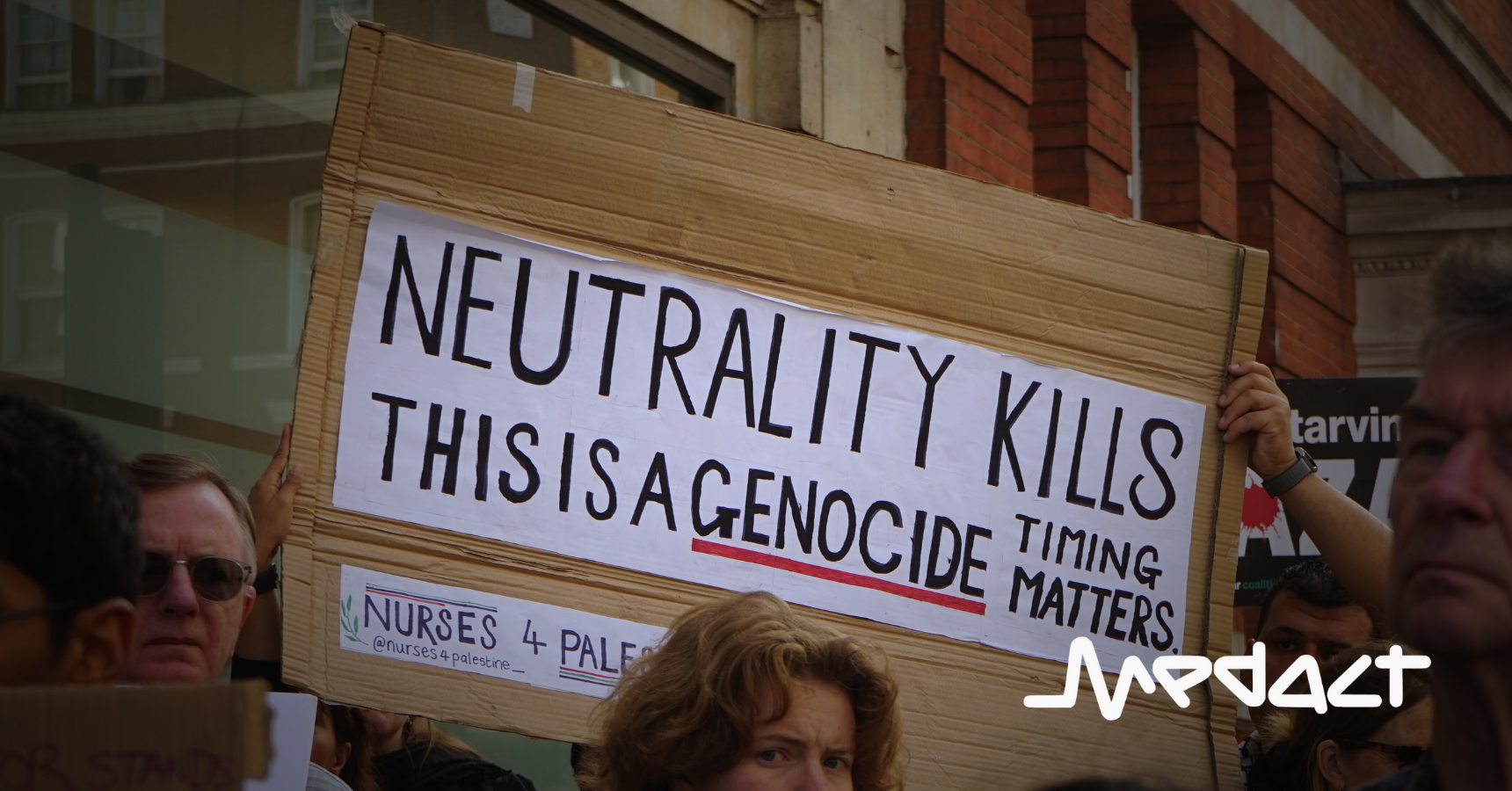 Protest placard "Neutrality kills. This is a genocide. Timing matters" by Nurses 4 Palestine